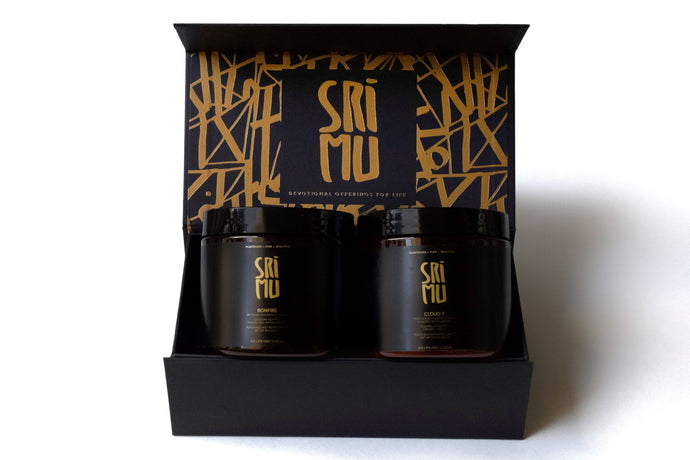 Two jars in a black and gold box